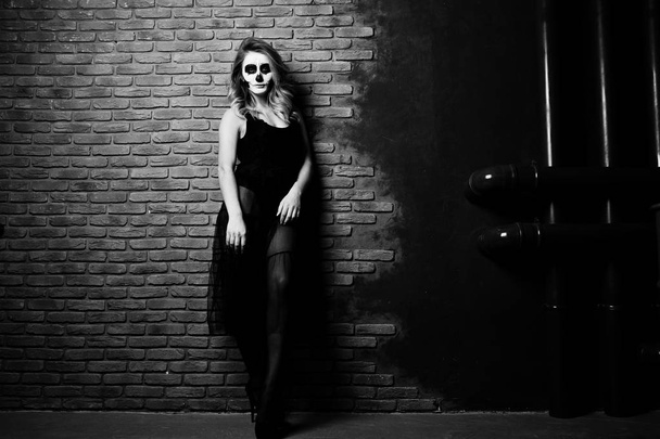Halloween skull make up girl wear in black against brick wall at - Фото, изображение
