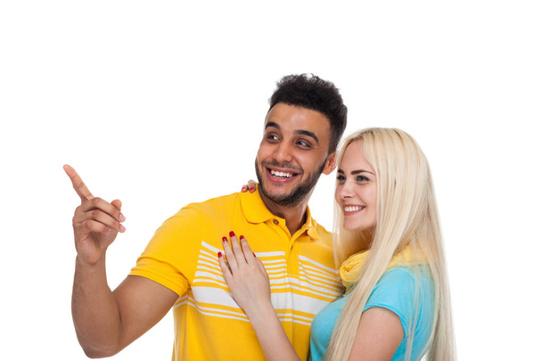 Ευτυχής όμορφη νεαρό ζευγάρι αγάπη χαμογελώντας αγκαλιάζουν, Ισπανόφωνος άνδρας γυναίκα σημείο δάχτυλο στο κενό αντίγραφο χώρο - Φωτογραφία, εικόνα