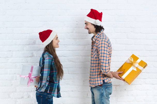 Christmas Holiday Happy Couple Hold Surprise Present Boxes Wear New Year Santa Hat Cap, Man And Woman Smiling - Фото, изображение