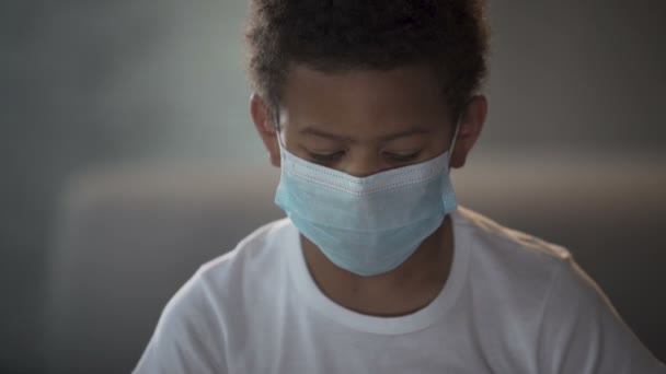 Afro-amerikai gyermeket orvosi maszkot látszó-ba kamera-szomorú szemekkel - Felvétel, videó