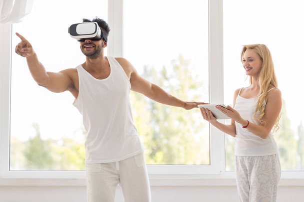 Hispanic Man Wear Virtual Reality Digital Glasses, Happy Smiling Girl Using Tablet - Photo, image