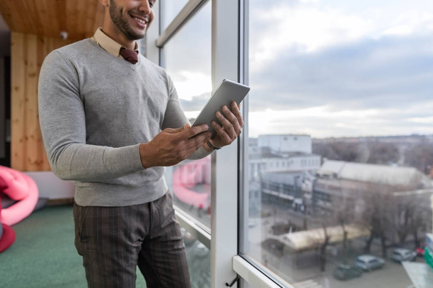 Hispanic Business Man Using Tablet Computer Stand In Front Panoramic Window Happy Smiling Businessman - 写真・画像