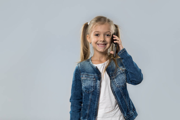 Beautiful Little Girl Speak Cell Smart Phone Call Happy Smiling Wear Jeans Coat Isolated - Foto, immagini