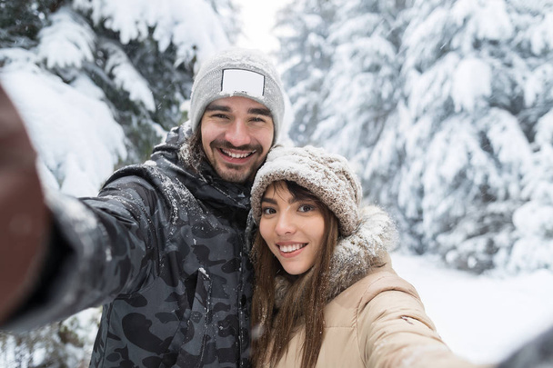 Man Taking Selfie Photo Young Romantic Couple Smile Snow Forest Outdoor - Foto, Imagen