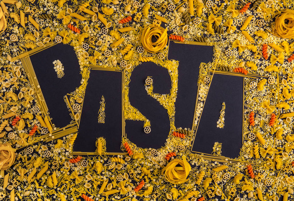Word Pasta made from different types of pasta products on a blac - Valokuva, kuva