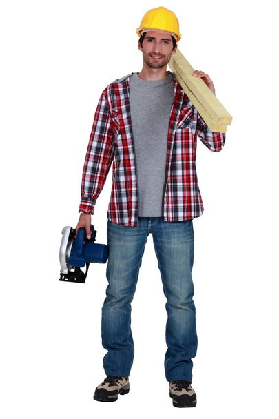 Craftsman holding a board and an electric saw - Фото, зображення