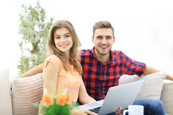 young man and girl sitting in front of an open laptop - Foto, Imagem