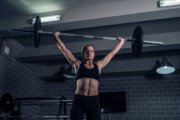 Athletic woman lifting a weight training at the gym. CrossFit - Fotografie, Obrázek