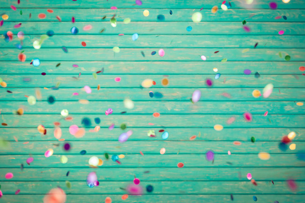 Confetti falling on wooden background - Foto, afbeelding