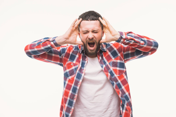 Screaming shocked bearded man in casual looking camera and screaming isolated over white - 写真・画像