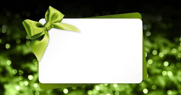greeting gift card with green ribbon bow isolated on green  - Фото, изображение