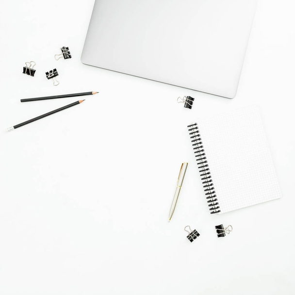 Office desktop workspace with silver laptop, notebook and pen on white background. Top view. Flat lay   - Foto, imagen