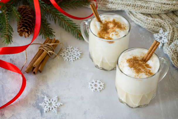 Homemade Eggnog Christmas milkshake with cinnamon, served in two - Foto, afbeelding
