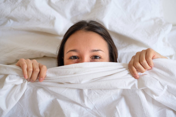 Mujer ojos abiertos acostada en la cama
 - Foto, imagen