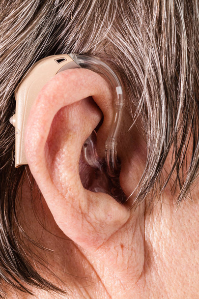Closeup senior woman using hearing aid - Valokuva, kuva