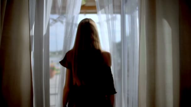 Een vrouw gaat naar de buiten doorsnijdt gordijnen - Video