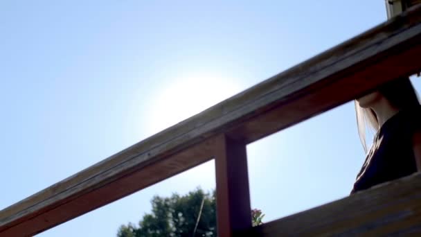 Mulher bonita de pé e apoiando-se em grades na varanda
 - Filmagem, Vídeo