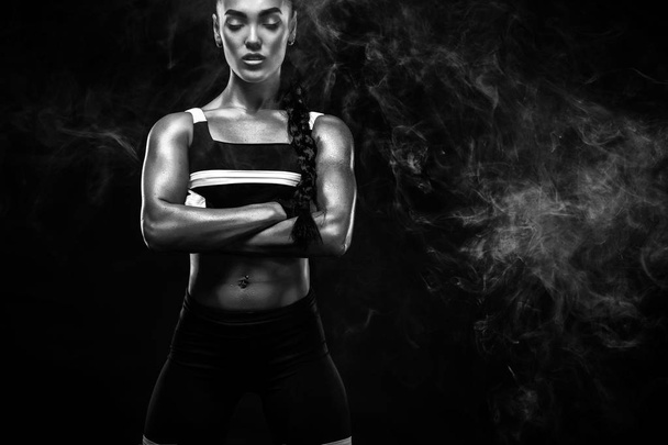 Sporty beautiful afro-american model, woman in sportwear makes fitness exercising at black background to stay fit - Photo, image