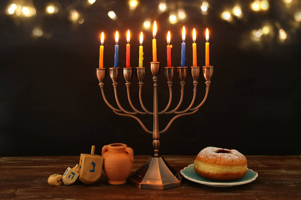 image of spinnig top, menorah (traditional candelabra) and burning candles - Fotó, kép