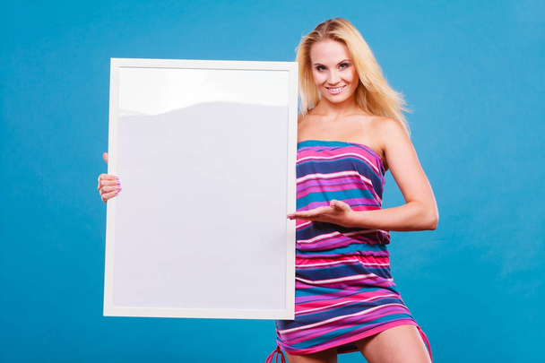 Happy positive blonde woman holding blank white board - Foto, Imagen