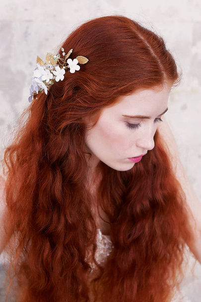 Beautiful red-haired girl with long curly hair in the bride, in a long lace dress.A natural beauty. - Photo, Image