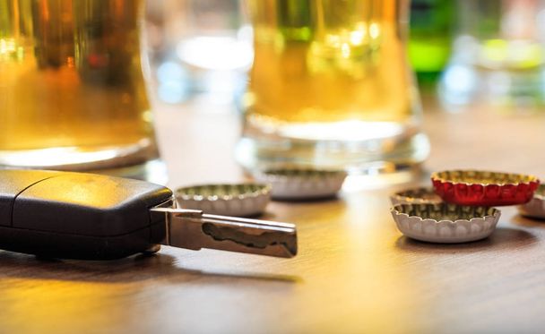 Drinking and driving. Car key on a wooden bar counter - Photo, Image