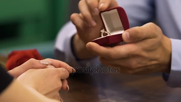Man opening box with diamond engagement ring, woman touching his hands, proposal - 映像、動画