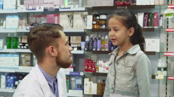 Ένα φιλικό φαρμακοπώλη χειραψία με ένα μικρό κορίτσι - Πλάνα, βίντεο