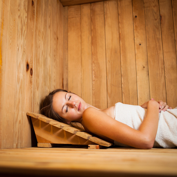 Young woman relaxing in a sauna - Foto, immagini