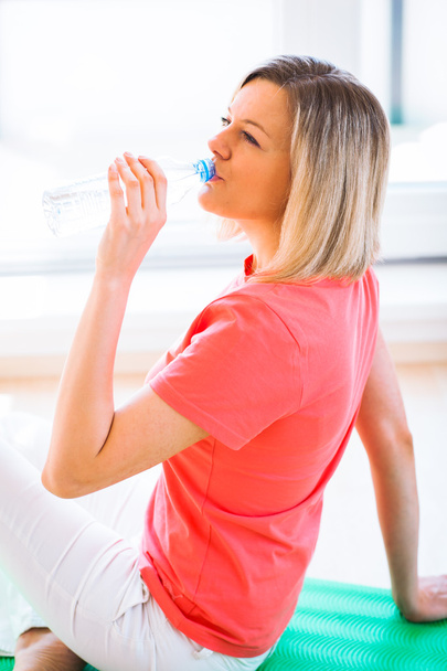 Pretty young woman refreshing during workout at home - Photo, image