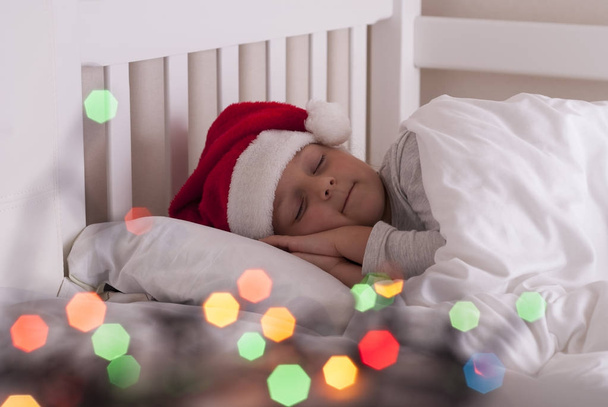 ragazza in cappello di Babbo Natale sul letto
 - Foto, immagini