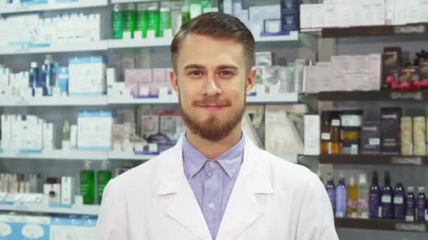 Young pharmacist showing medication and smiling - Footage, Video