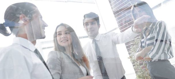 from behind the glass.business team in the officce - Foto, imagen