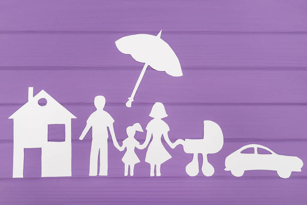 Siluety z papíru muže a ženy s dvěma dívkami pod deštník, dům a auto poblíž - Fotografie, Obrázek
