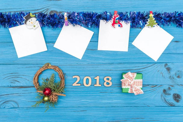 Papírové samolepky a nový rok ornamenty a hračky na modré dřevěné pozadí - Fotografie, Obrázek