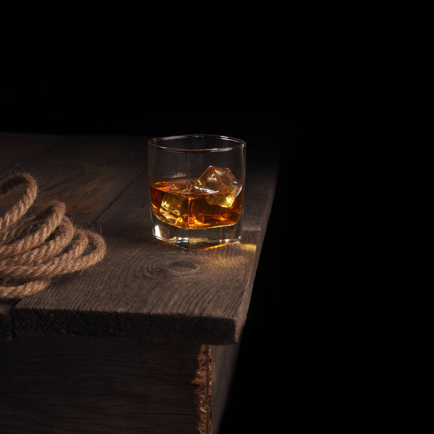 Glass of whiskey on rustic table.black background - Foto, Bild