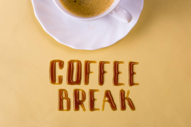 Coffee break. Letters of spilled coffee and a cup - Fotoğraf, Görsel