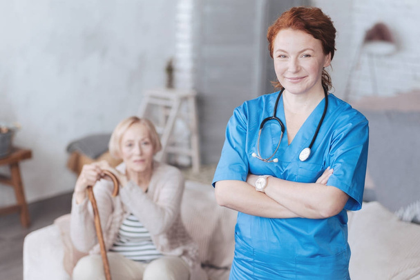 Cheerful mature nurse posing with arms crossed - Zdjęcie, obraz
