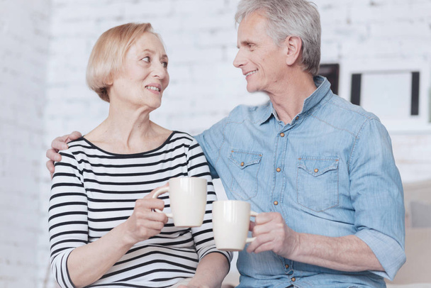 Adorable senior couple drinking tea at home - Foto, afbeelding
