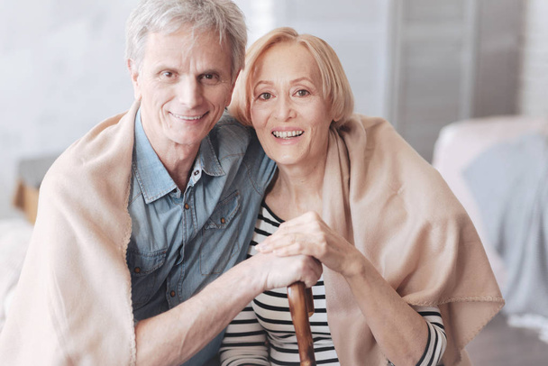 Adorable retired couple embracing and smiling into camera - Zdjęcie, obraz