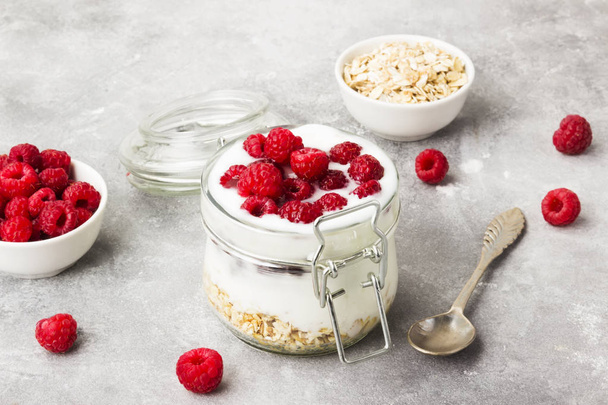 Glanola in glass jar with raspberry and mint on a gray backgroun - Foto, immagini