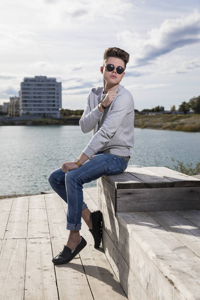 Lifestyle portrait of a young man wearing casual clothes and sunglasses - Photo, image