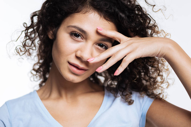 Close up of curly woman posing with fingers near eye - Photo, Image