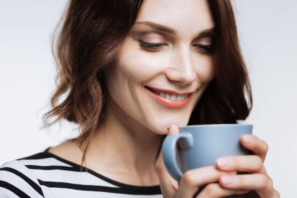 Close up of beautiful woman smelling coffee aroma - Foto, Imagen