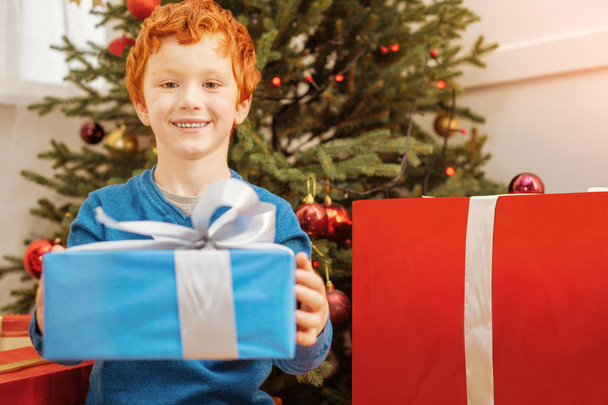 Thoughtful little boy handing over christmas present - Valokuva, kuva