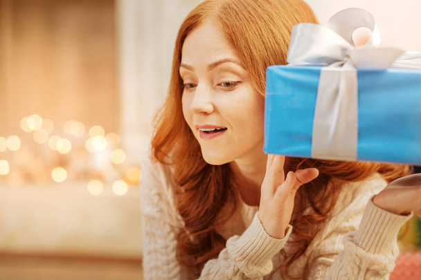 Curious redhead lady guessing what she got for christmas - Fotoğraf, Görsel