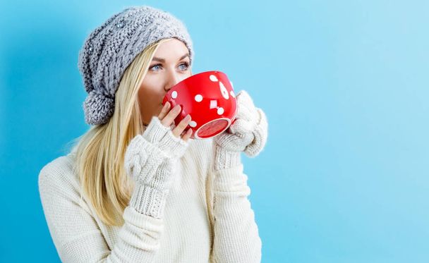 Woman in winter clothes drinking coffee - Фото, изображение