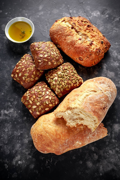 Freshly baked bloomer, ciabatta bread and sandwich buns served with thyme infused extra virgin olive oil - Foto, Imagen