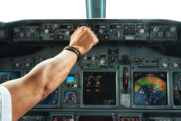 Ręka pilota działa przełącznik na panele samolotu. - Zdjęcie, obraz
