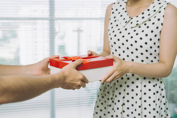 Mano masculina dando regalo rojo a la mujer
 - Foto, imagen